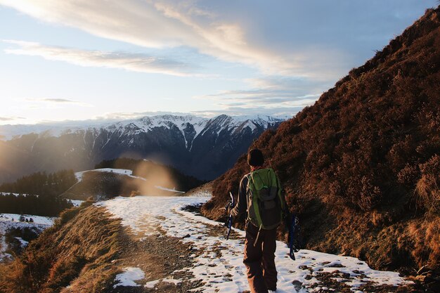 Detrás de la foto del excursionista en las montañas cubiertas de nieve.