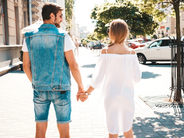 Detrás de la hermosa niña y su guapo novio cogidos de la mano