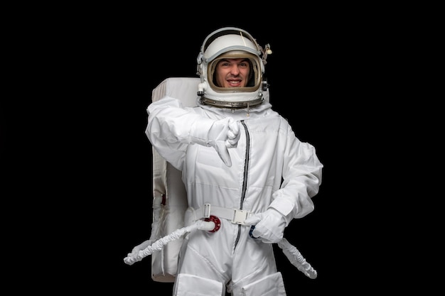 Día del astronauta astronauta en el casco del traje espacial del cosmos que muestra un gesto de señal de mala mano no feliz