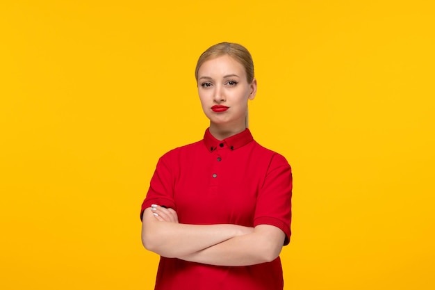 El día de la camisa roja molestó a una chica rubia con una camisa roja sobre un fondo amarillo