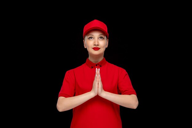 Día de la camisa roja niña rezando tomados de la mano en una gorra roja con camisa con lápiz labial