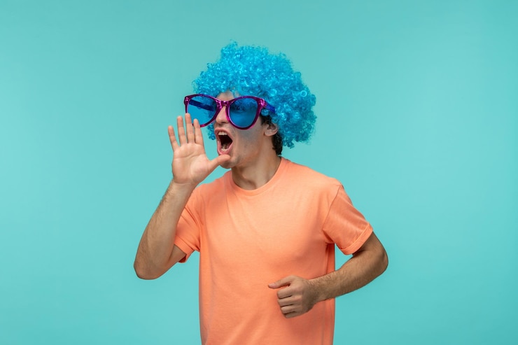 Foto gratuito día de los inocentes chico payaso gritando cabello azul rosa gafas de sol grandes gritos divertidos