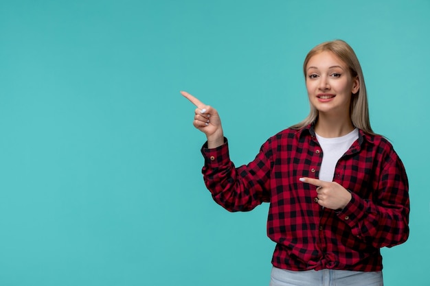 Día internacional de los estudiantes feliz linda dama en camisa roja a cuadros apuntando a la izquierda