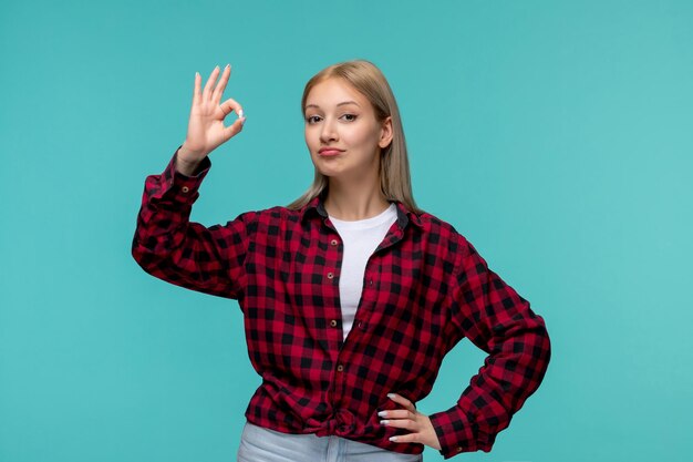 Día internacional de los estudiantes joven linda chica en camisa roja a cuadros que muestra el signo ok