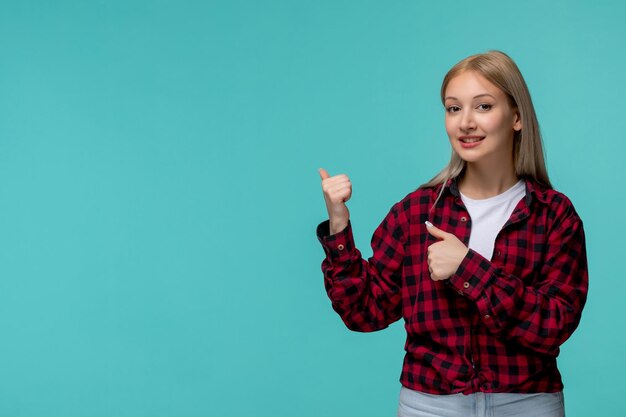 Día internacional de los estudiantes joven linda chica en camisa roja a cuadros sonriendo y apuntando hacia atrás