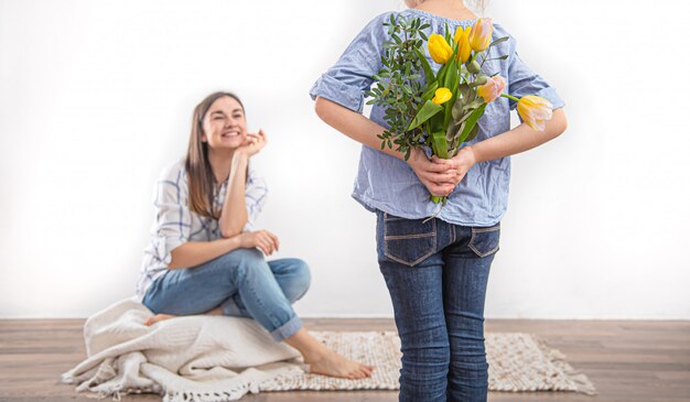 El día de la madre, una pequeña hija le da a su madre un ramo de tulipanes.