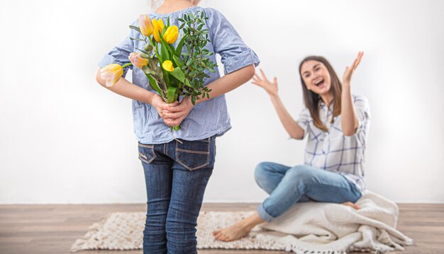 El día de la madre, una pequeña hija le regala a su madre un ramo de tulipanes.