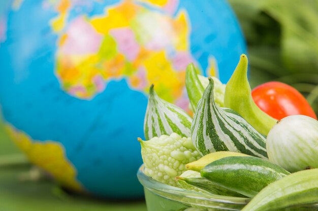Día Mundial de la Alimentación. Muchas verduras están en un tazón con globos colocados cerca de las hojas de plátano verde.
