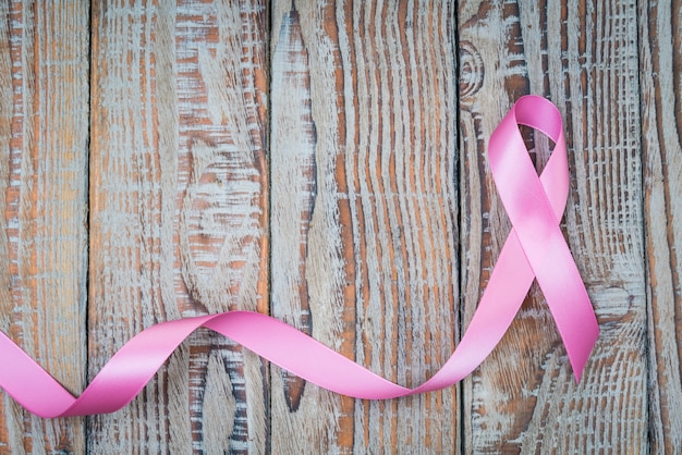día Mundial del Cáncer: Cinta contra el cáncer de mama en la madera Backgr