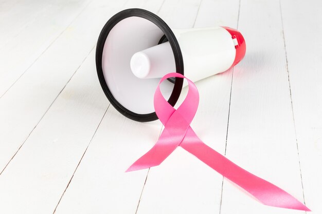 Día mundial del cáncer con cinta rosa y megáfono.