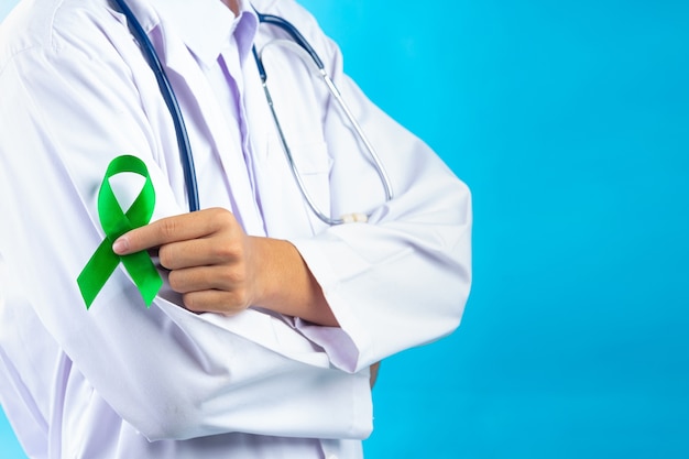 Día mundial de la salud mental. mano del doctor sosteniendo la cinta verde