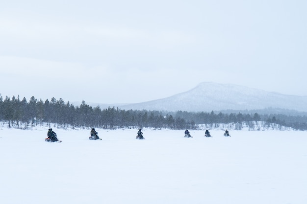 Día de nieve con gente en motos de nieve en el norte de Suecia