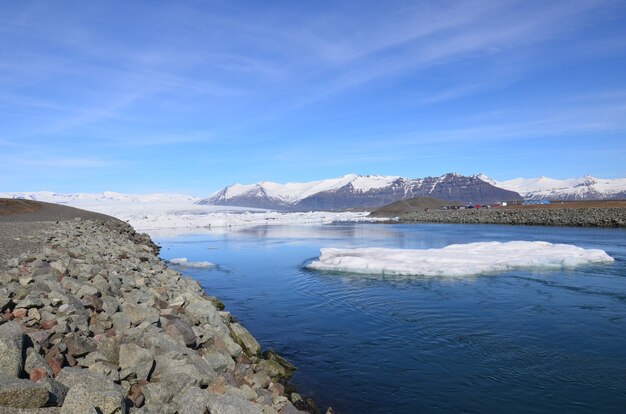 Día de primavera con un camino de agua y montañas en Islandia