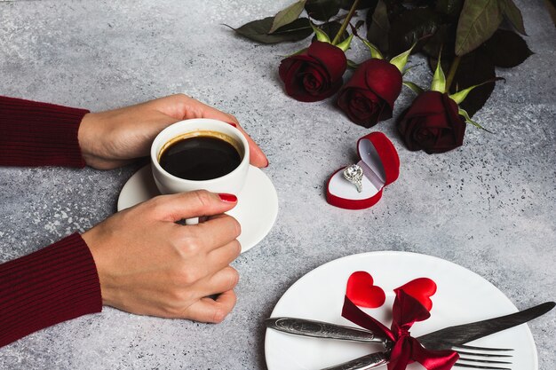 Día de San Valentín cena romántica mesa ajuste mujer mano sosteniendo una taza de café