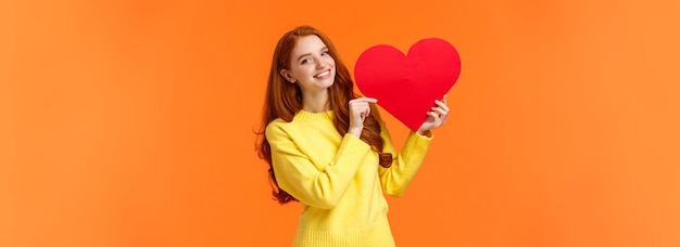 El día de San Valentín es el momento perfecto para confesar a una linda mujer pelirroja romántica y tierna con suéter amarillo.