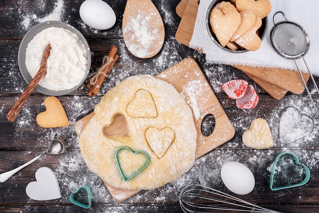 Día de San Valentín en forma de corazón en masa con utensilios de cocina