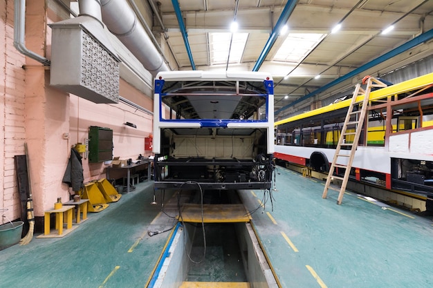 Un día de trabajo de fabricación de autobuses automáticos modernos con trabajadores de automóviles sin terminar con antecedentes de piezas de automóviles uniformes de protección