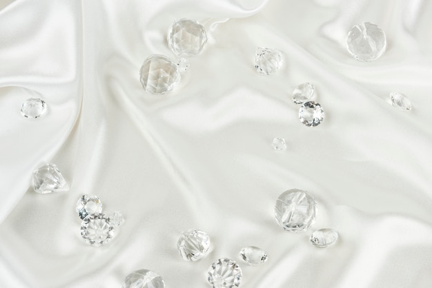 Diamantes transparentes decorativos sobre tela blanca con textura