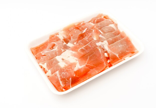 Diapositiva de carne de cerdo cruda sobre fondo blanco.