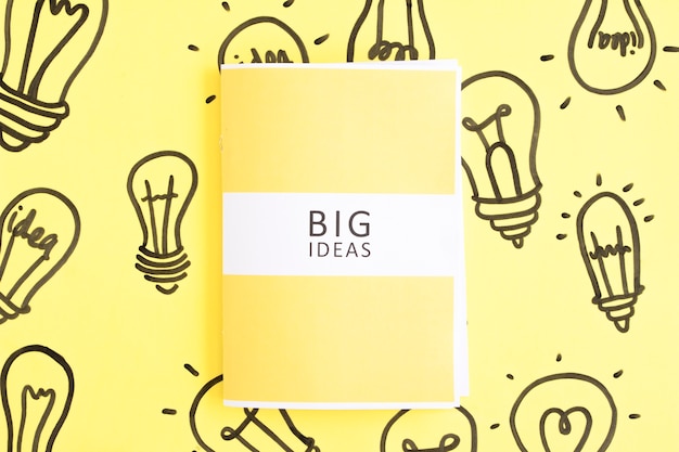Diario de grandes ideas en mano dibujado bombilla sobre fondo amarillo