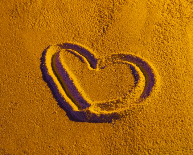 Dibujado en forma de corazón sobre textura de arena
