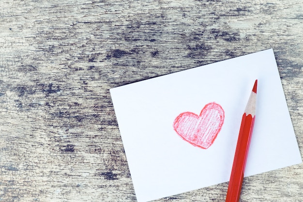 Dibujado a mano de corazón rojo tarjeta de San Valentín sobre fondo de madera oxidado