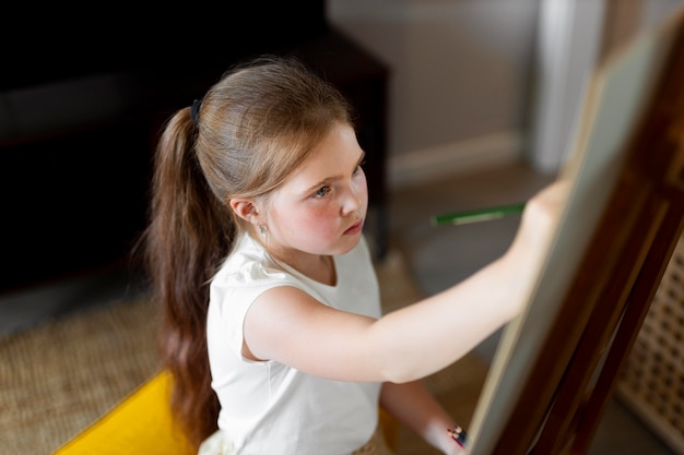 Dibujo de niña con caballete