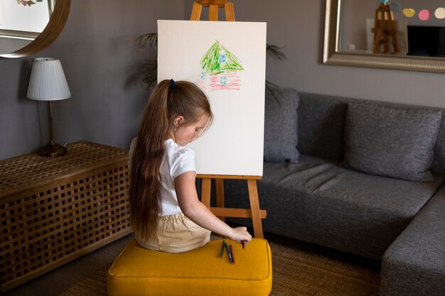 Dibujo de niña con caballete