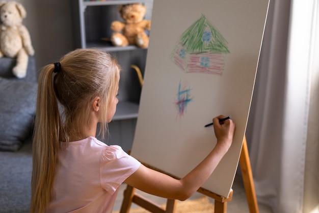 Dibujo de niña con caballete