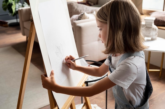 Foto gratuita dibujo de niña en casa plano medio