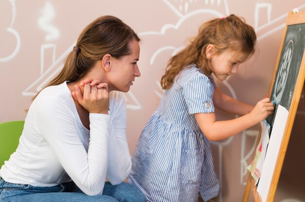 Dibujo de niña de primer plano en la pizarra