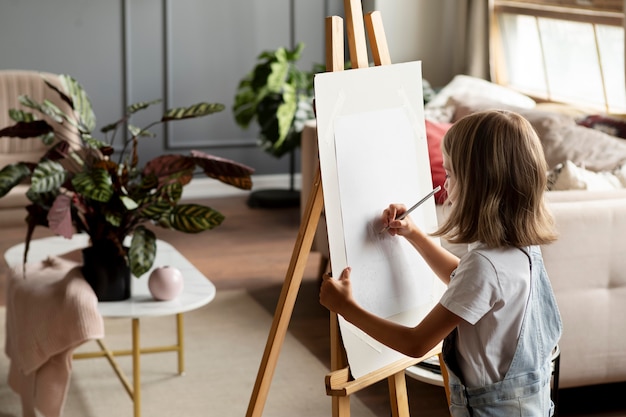 Foto gratuita dibujo de niña de tiro medio en casa