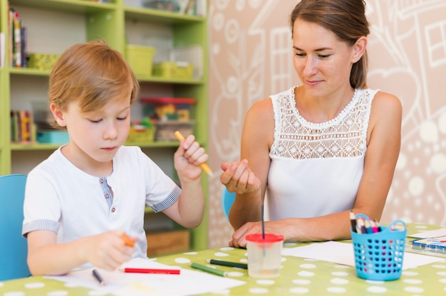 Foto gratuita dibujo de niño de tiro medio en la mesa