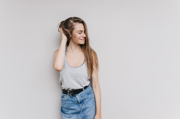 Dichosa chica blanca en traje casual posando. Filmación en interiores de mujer joven feliz con peinado largo expresando emociones positivas.