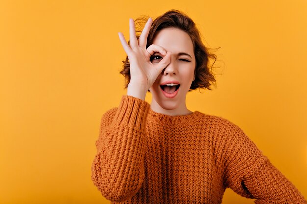 Dichosa mujer joven con piel pálida haciendo muecas durante el photosoot