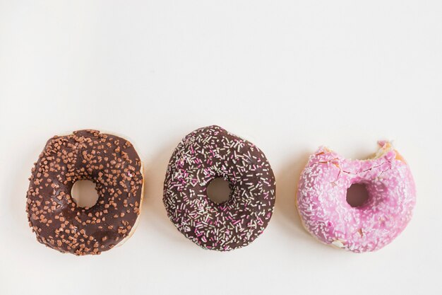 Diferente tipo de donuts cocidos en el fondo blanco