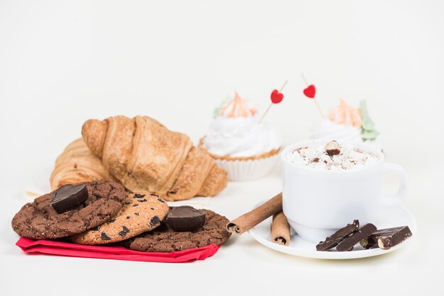 Diferentes dulces con taza de café en la mesa