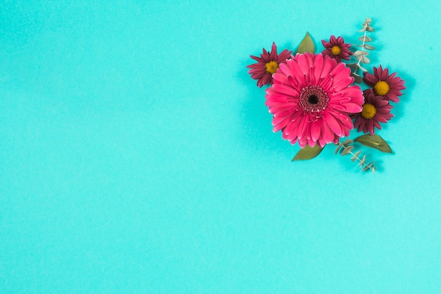 Diferentes flores con hojas en mesa.