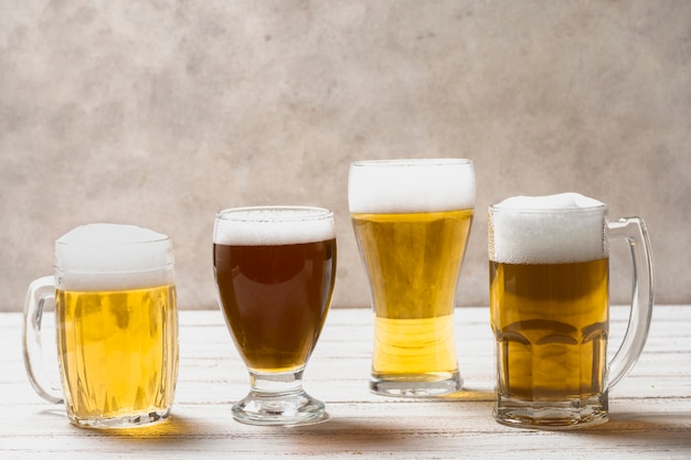 Foto gratuita diferentes formas de vasos con cerveza en la mesa
