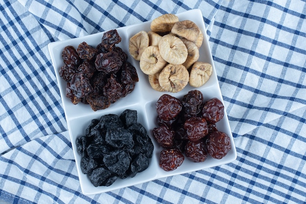 Foto gratuita diferentes frutos secos en un tazón, sobre el paño de cocina, sobre la mesa de mármol.