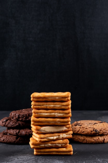 Diferentes galletas en superficie oscura