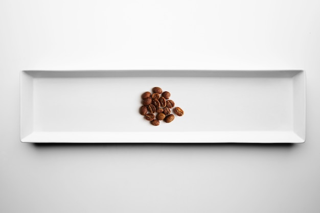 Diferentes grados de tostado de café artesanal profesional aislado en un plato blanco, vista superior
