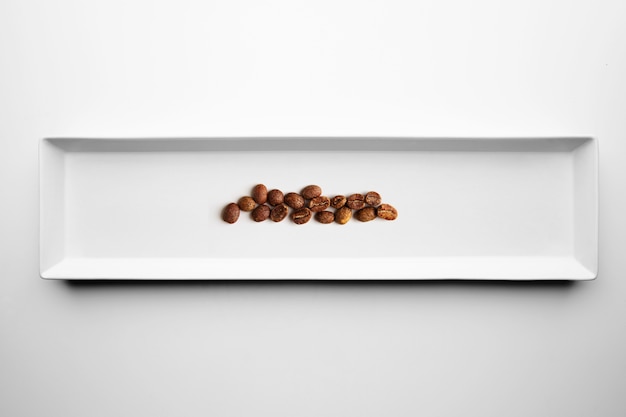 Diferentes grados de tostado de café artesanal profesional aislado en un plato blanco, vista superior