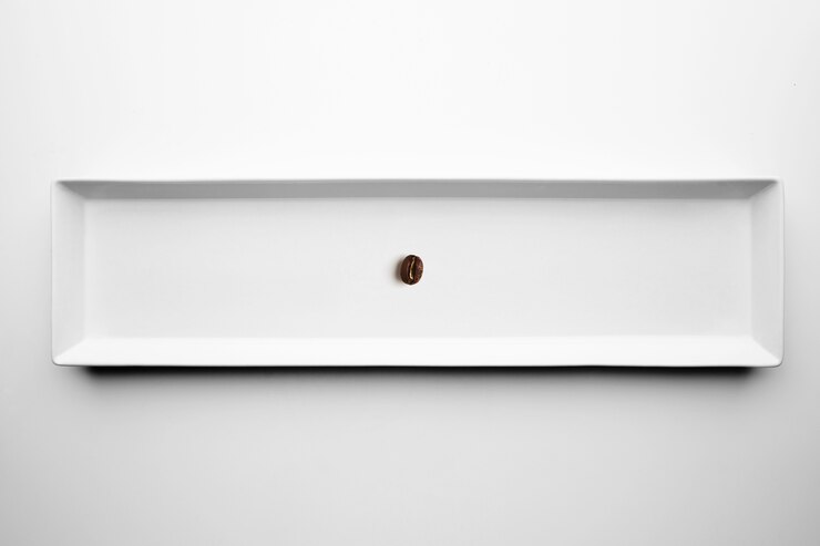 Foto gratuito diferentes grados de tostado de café artesanal profesional aislado en un plato blanco, vista superior