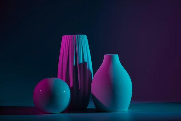 Diferentes jarrones modernos con arreglo de luz azul y violeta.