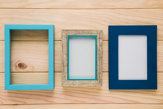 Diferentes marcos azules con fondo de madera.