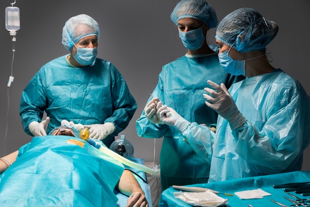 Diferentes médicos que realizan un procedimiento quirúrgico en un paciente.