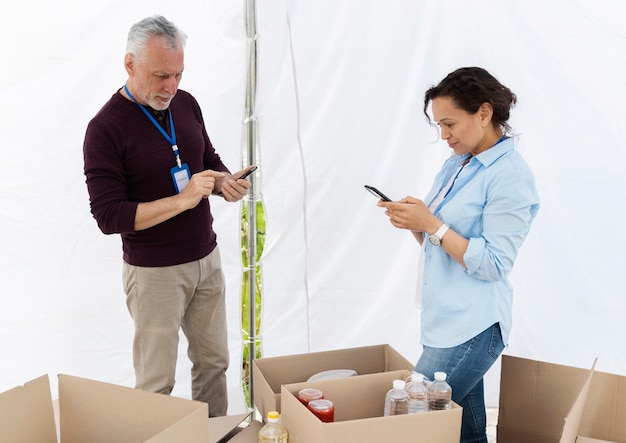 Foto gratuita diferentes personas haciendo trabajo voluntario en un banco de alimentos.