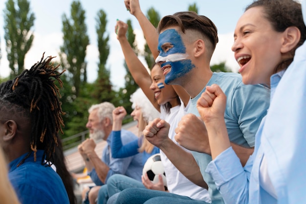 Diferentes personas mirando un equipo de fútbol.