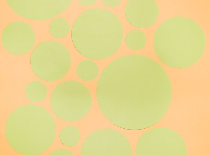 Foto gratuito diferentes tipos de círculos de papel verde sobre un fondo naranja